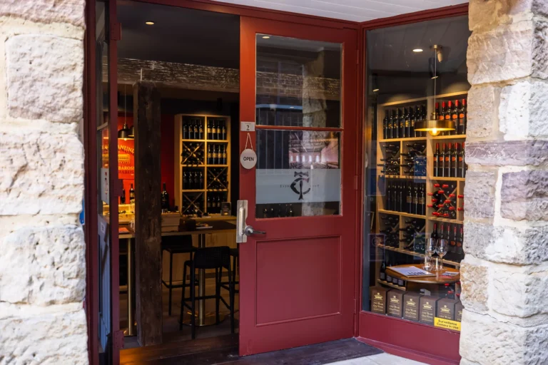 Historic sandstone wine bar storefront in The Rocks with burgundy doors and wine displays.