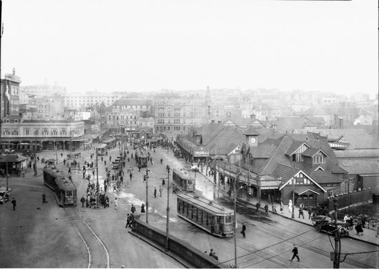 Historic Circular Quay precinct from 1930 with trams, colonial buildings, and harbour structures.