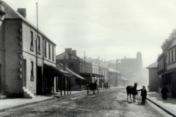 Historic cobblestone street lined with colonial-era buildings in The Rocks Sydney.