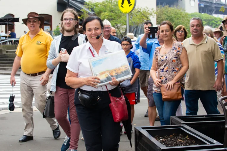 Tour guide leads group of visitors through historic Sydney street on guided walking tour.