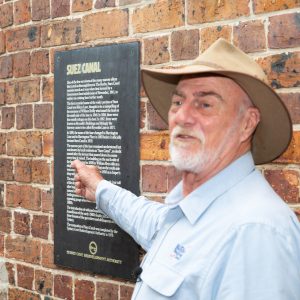 a man standing in front of a brick building